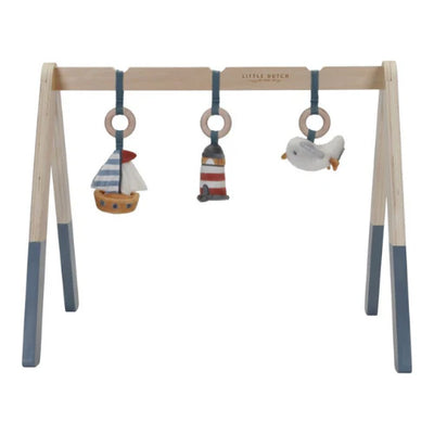 Wooden baby gym with hanging toys featuring a sailboat, lighthouse, and seagull on a white background.